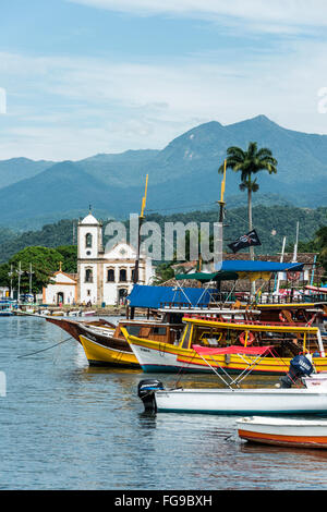 Ausflugsboote warten auf Touristen in der Nähe von der Kirche Igreja de Santa Rita de Cassia in Paraty Stockfoto