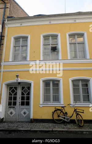 Gelbe Hipster Fahrrad vor einem gelben Stadt Gebäude Stockfoto