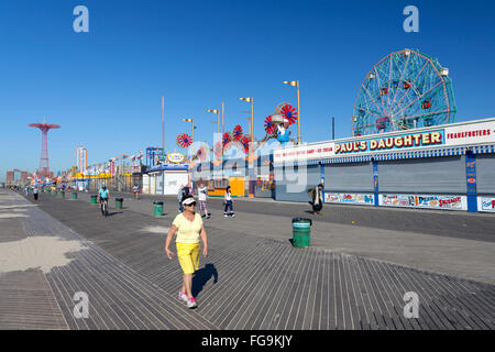 Menschen zu Fuß und Fahrrad auf Coney Island Promenade am Septembermorgen im hellen Sonnenlicht Stockfoto