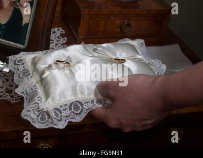 Details der Hochzeit Ringe auf dem Kissen mit hand Stockfoto