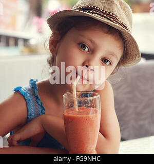 Spaß süßes Kind Mädchen in Straße Restaurant gesunde Smoothie-Saft zu trinken. Closeup getönten Porträt Stockfoto