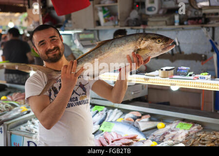 Ein Fischhändler hält einen frisch gefangenen Fisch auf dem Fischmarkt, Fethiye, Türkei Stockfoto