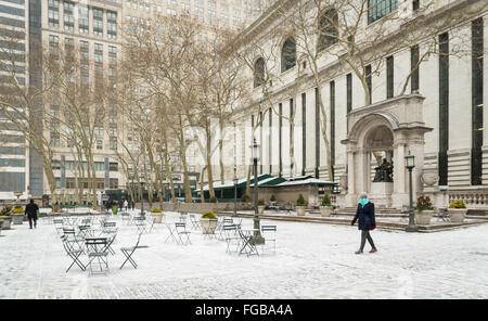 Frau geht durch die obere Terrasse im Bryant Park als Schnee beginnt zu den Boden bedecken. Stockfoto