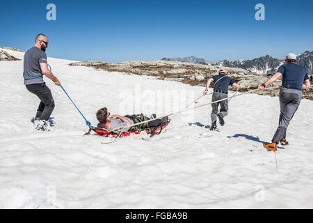 Menschen eine Ausbildung für eine Evakuierung im Notfall mit Schlitten in den französischen Alpen Stockfoto
