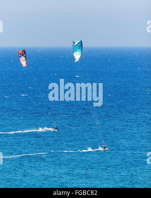 Zwei Männer Kitesurfen in den Kristall-Buchten von Zypern. Ein Wassersport, bei dem eine Kitesurfer steuert einen Power-Kite und reitet die Wellen auf, eine Stockfoto