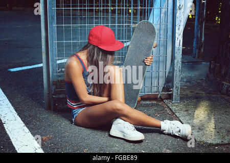 Skater-Girl auf der Straße sitzen. Städtischen Schuss Stockfoto