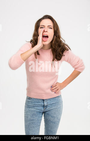 Junge Frau schreiend auf einem weißen Hintergrund isoliert Stockfoto