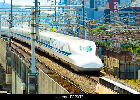 Annäherung an Shinkansen-Hochgeschwindigkeitszug auf hohe erhöhten Schienen umgeben von Drähten gesehen von oben Luftbild verlassen Stadt Kyoto Stockfoto