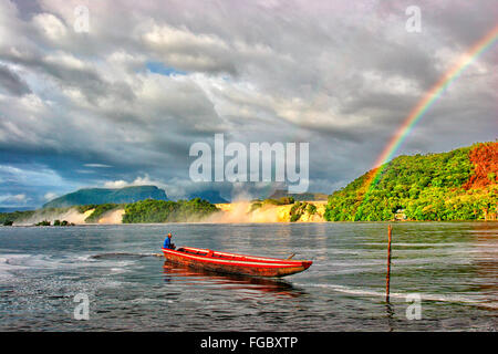 Boote auf Laguna de Canaima (Canaima Lagune) mit Saltos Hacha (Hacha Wasserfälle) und Tepuis (Flat-Top Berge) im Hintergrund. Stockfoto