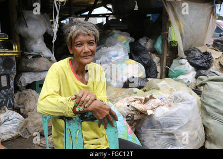 Frau arbeitet in einem Mülltrennung und Weiterverkauf in einem Junk-e-Shop in der Nähe der Quezon City integrierte verschwenden Endlagers in Barangay (Dorf) Payatas in Quezon Stadt, Metro Manila, Philippinen Stockfoto