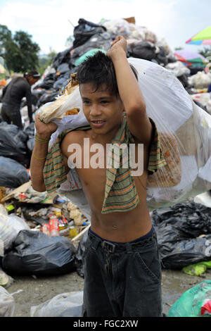 Junge (14) arbeitet in einer Mülltrennung und Weiterverkauf in einem Junk-e-Shop in der Nähe der Quezon City integrierte verschwenden Endlagers in Barangay (Dorf) Payatas in Quezon Stadt, Metro Manila, Philippinen Stockfoto