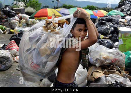 Junge (14) arbeitet in einer Mülltrennung und Weiterverkauf in einem Junk-e-Shop in der Nähe der Quezon City integrierte verschwenden Endlagers in Barangay (Dorf) Payatas in Quezon Stadt, Metro Manila, Philippinen Stockfoto