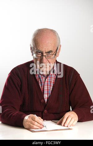senior Greis tragen Brillen, arbeiten mit Dokumenten, mit Stift ernst mit roten Pullover Stockfoto