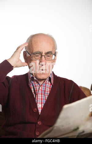senior Greis tragen Brillen, Zeitung lesen, Fragen, mit roten Pullover Stockfoto