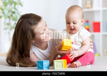 Mutter und Baby Mädchen spielen mit Entwicklungsstörungen Spielzeug im Wohnzimmer Stockfoto