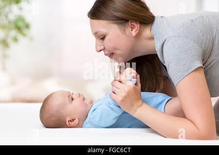 fröhliche Mutter spielen und Turnen ihr Baby Kleinkind Stockfoto