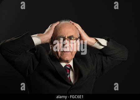leitenden Geschäftsmann tragen Brillen auf schwarzem Hintergrund betont in Schwierigkeiten Stockfoto