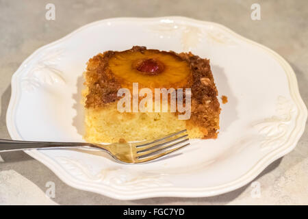 Eine Portion Ananas auf den Kopf nach unten Kuchen, mit braunem Zucker, Ananasscheiben, Marascheno Kirschen und Pecan-topping Stockfoto