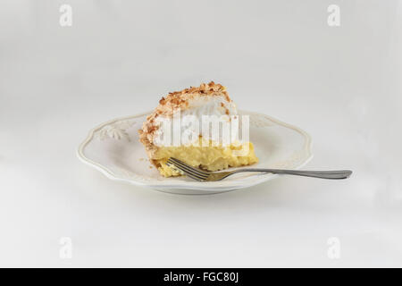 Ein Stück hausgemachte frisch gebackene Kokos Sahne Baiser Torte isoliert auf weiss. Stockfoto