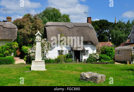 Überqueren Sie das Martin Village Green mit einem strohgedeckten Häuschen im Hintergrund in Hampshire, Großbritannien Stockfoto