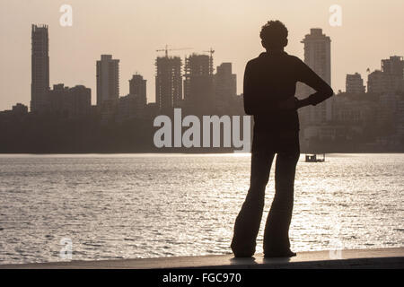 Indien Mumbai Bombay Chowpatty Beach Kerl über Strand bei Sonnenuntergang Blick auf Malabar Hill. Stockfoto