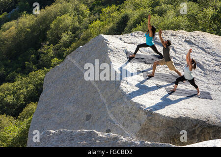 Drei Menschen vollbringen Yoga Stockfoto