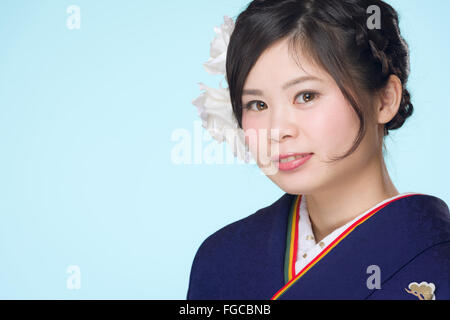 Ein Porträt von einem schönen junge japanische Mädchen in einem blauen Kimono für ihr kommen des Alters Zeremonie an ihrem 20. Geburtstag.