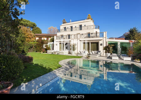 Architektur; schönes Haus mit Pool, blauer Himmel und üppigen Garten Stockfoto