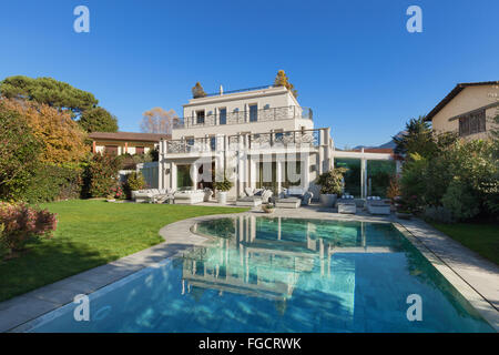 Architektur; schönes Haus mit Pool, blauer Himmel und üppigen Garten Stockfoto