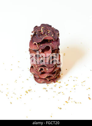 Ein Stapel von dünne runde rote Beete Chips gebacken im Ofen mit Oregano und Salz gestapelt auf weißem Hintergrund. Eine gesunde, vegetarische, v Stockfoto