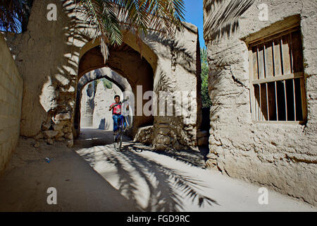 Junge mit dem Fahrrad in der Straße in Nizwa, eine berühmte Stadt in Bergen von Oman. Stockfoto