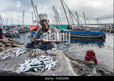 Man kleine Fische in einem einfachen Stall am Hafen zu verkaufen. Stockfoto