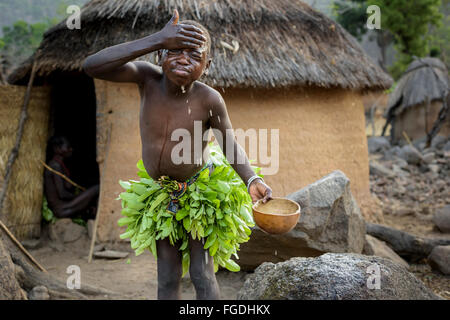 Koma-Mädchen aus den Bergen Atlantika gekleidet mit traditionellen Blätter Kleid waschen Sie ihr Gesicht am frühen Morgen. Stockfoto