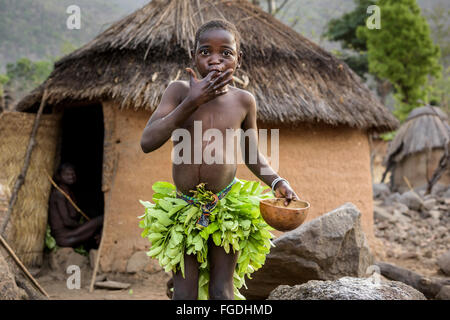 Koma-Mädchen aus den Bergen Atlantika gekleidet mit traditionellen Blätter Kleid waschen Sie ihr Gesicht am frühen Morgen. Stockfoto