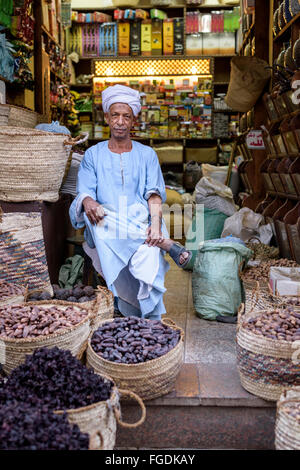 Porträt von einem mittleren Alters Ladenbesitzer mit Turban verkaufen Datteln und anderen waren in einem kleinen Laden. Stockfoto