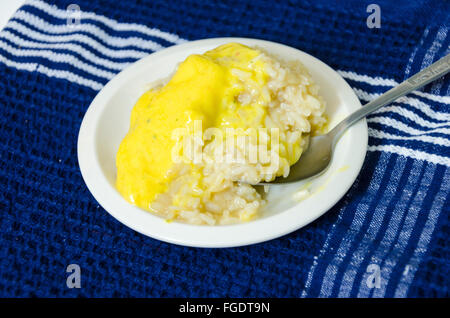 Mango sticky glutinous Reis auf einem Teller auf einem blauen Tuch. Eine köstliche asiatische thailändische Küche Dessert mit Sahne, Kokosmilch Stockfoto