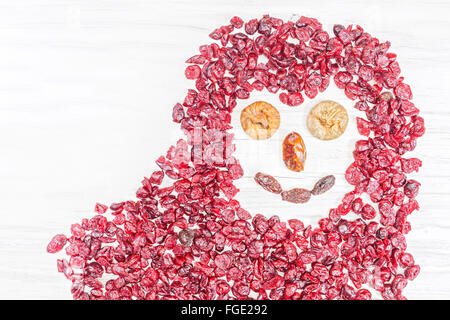 Lustiges Gesicht von getrockneten Früchten auf weißem Hintergrund aus Holz gemacht. Stockfoto