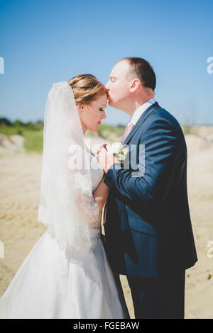 blonde Braut und Bräutigam auf einem sand Stockfoto
