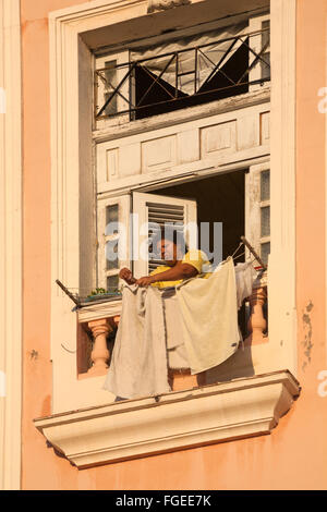 Alltag in Kuba - kubanische Frau hängen Wäsche auf Balkon in Havanna, Kuba, Karibik, Karibik, Mittelamerika Stockfoto