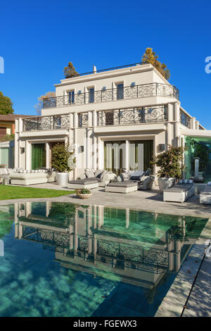 Architektur; schönes Haus mit Pool, blauer Himmel und üppigen Garten Stockfoto