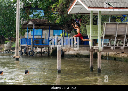 Koh Kred. Kinder spielen im Fluss. Haus gebaut auf Pfählen am Rande der Kro Kred Insel in der Nähe von Bangkok Thailand Stockfoto