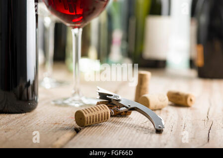 Korkenzieher mit Kork in der Nähe von Glas Wein und eine Flasche eingefügt Stockfoto