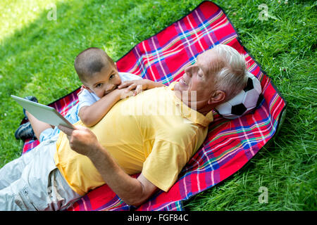 Großvater und Kind im Park mit tablet Stockfoto