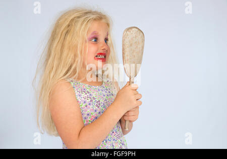 Junges Mädchen mit blonden Haaren tragen verschmierte Make-up überrascht selbst in den Spiegel schauen Stockfoto