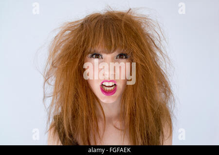 Porträt einer Frau mit chaotisch zerzausten Haaren mit und Ausdruck von Wut Stockfoto