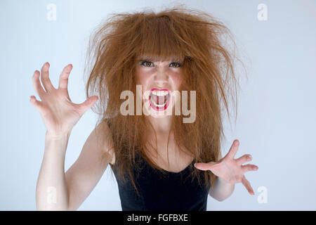 Frau mit chaotischen Wirren langen braunen Haaren zu kämpfen, schreien Stockfoto