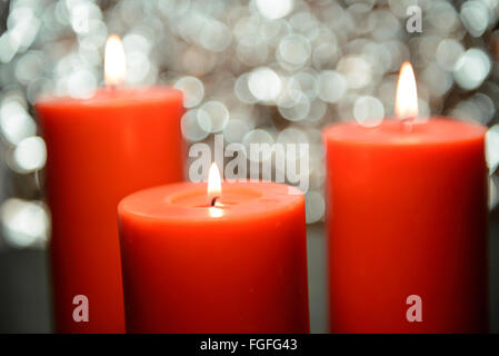 drei große aromatische Kerzen leuchten vor schönen Bokeh Hintergrund, Valentinstag Stockfoto