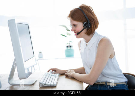 grimassierende Hipster-Business-Frau, die auf ihrem computer Stockfoto