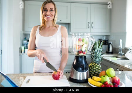 Hübsche blonde Frau bereitet einen smoothie Stockfoto