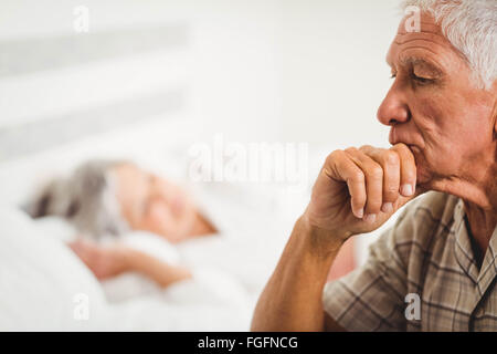 Besorgt senior Mann sitzt auf Bett Stockfoto